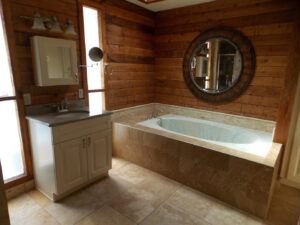 Bathroom with a sink, cabinet, and large bathtub