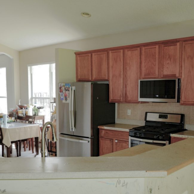 Dated kitchen interior featuring honey oak cabinetry and basic white laminate countertops.