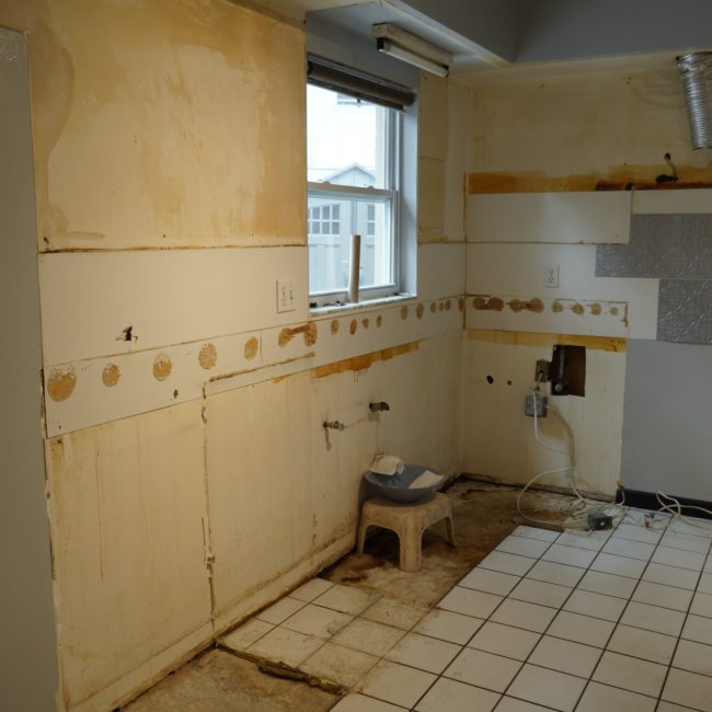 Kitchen wall stripped to the studs during a full interior home remodeling project.