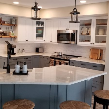 Modern kitchen with white cabinets and a large island with stools.