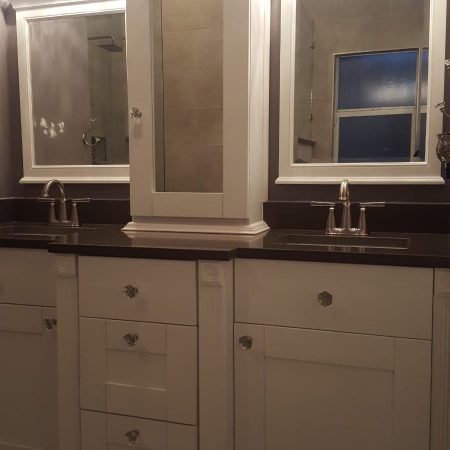 Elegant white bathroom vanity with two sinks and mirrors.