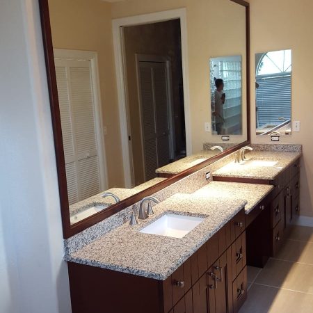 Clean bathroom with two sinks and a giant mirror on the wall